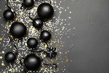 Beautiful Christmas balls, confetti and ribbons on dark background