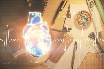 Double exposure of heart drawing and work table top veiw. concept of medical education.