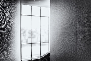 stained glass window flooded with sunlight and walls in perspective in the interior of the room, monochrome, blurred image