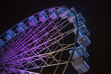 detalle de una noria de color morado vista desde abajo en una noche cerrada en San Sebastian