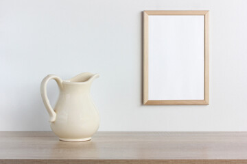 empty wooden frame and a white jug on a table