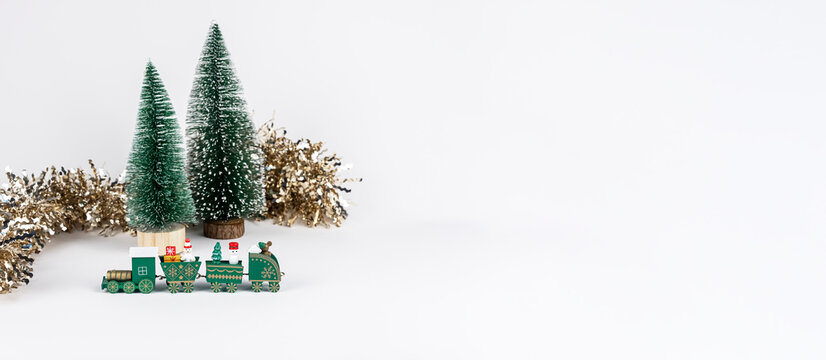 Christmas banner with toy train and fir trees on white background.