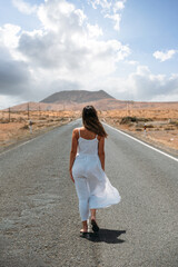 Fototapeta na wymiar Woman walking on road in highlands