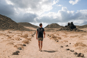 Fototapeta premium Traveling man on sandy mountain road