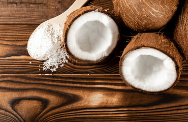 Fototapeta na wymiar coconut flakes on a wooden spoon, coconuts on a wooden background. Close-up. copy space.