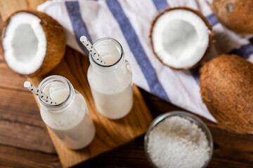 Coconut yogurt and coconuts on a wooden background. Close-up.