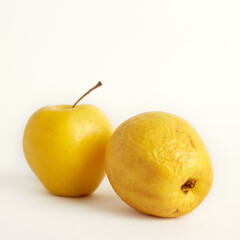 Shriveled yellow apples isolated on white background. Ugly food concept. Selective focus