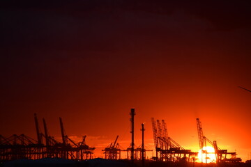 Fototapeta premium Flaming red sunset over an Oil Refinery in the Netherlands