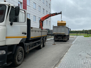 A large, powerful garbage truck unloads garbage with a manipulator for subsequent recycling of...