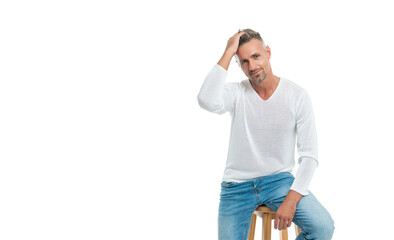 male fashion model in casual style clothes sit on chair isolated on white with copy space, fashion.