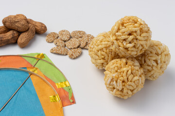Indian traditional sweets with kites for Makar Sankranti Or Lohri known as lai or laiya or murmure ball and chikki made of puffed rice gur or jaggery syrup with chikki and til or Sesame see