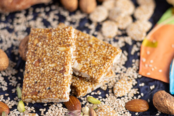 Winter delicacy Indian sweet or mithai with kites for Makar Sankranti Lohri Gajak Also Known As Til Patti Papdi Chikki Gur Gajjak Gazak GachakMade Of Jaggery Gud Almonds Badam And Pistachio