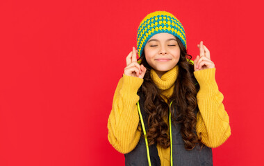 smiling kid with curly hair in hat make a wish. teen girl on red background.