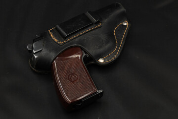 Pistol in leather holster on the black table