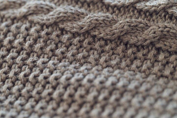 closeup of a light brown cable knit sweater with detailed yarn texture - background to create a cozy home lifestyle atmosphere