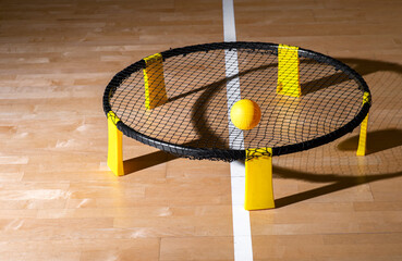 Spike ball game with yellow ball on hardwood court floor. Horizontal sport theme poster, greeting...