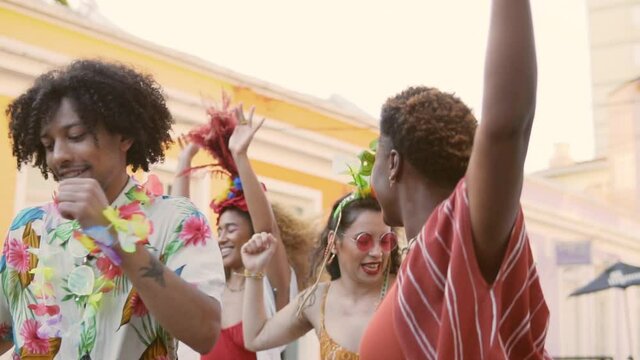 Carnival day in Brazil, woman and friends dance at street party. People in costumes celebrate Brazilian Carnaval