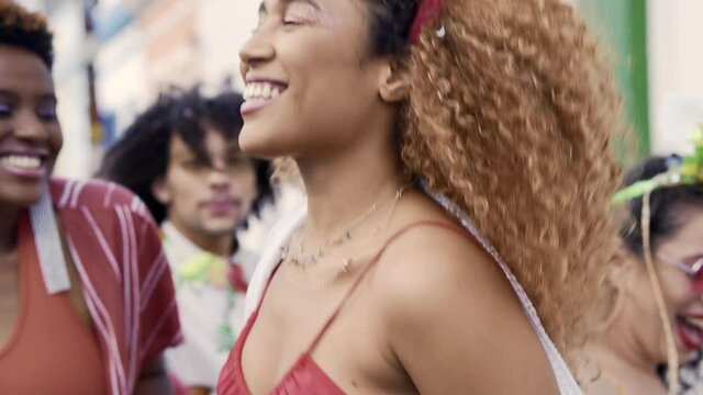 Woman dance during Carnival Day in Brazil. People in costume enjoy Brazilian party of Carnaval in the street