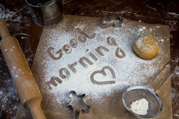 On the baking paper on the flour is written Good morning and heart, against the background of...