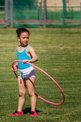 Niña con el aro hula hula como parte de su entrenamiento de atletismo en las instalaciones...