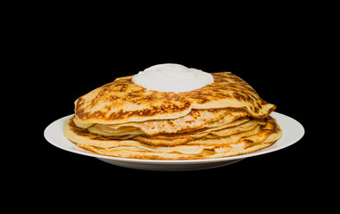 pancakes on a plate with sour cream isolated on black background