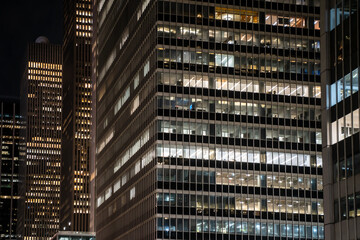 Modern New York City office building seen at night with lit windows