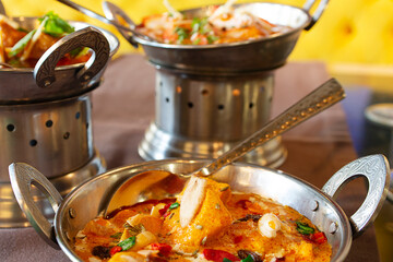 Indian food dishes with the typical mild and spicy curries in their traditional containers