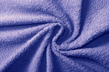Fototapeta na wymiar Crumpled fabric texture of towel close up in trendy tone of Very Peri 17-3938. Color of the Year 2022.