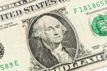 Close up of George Washington on old worn out US one dollar bill.