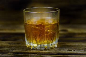 Glass of whiskey on the dark wooden background