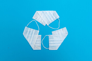Recycling symbol is made of face masks. Concept - medical garbage. Problem of waste disposal...