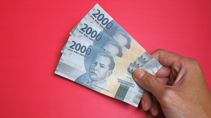 Rupiah the official currency of Indonesia. Business and finance concept. Uang 2000 Rupiah. Red...