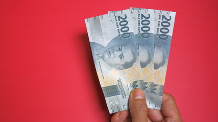 Rupiah the official currency of Indonesia. Business and finance concept. Uang 2000 Rupiah. Red...