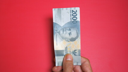 Rupiah the official currency of Indonesia. Business and finance concept. Uang 2000 Rupiah. Red...