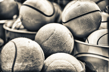 Yellow tennis balls and green basket balls on a bucket, sport co