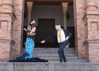 Man and woman dancing flamenco in the stairs of a traditional building