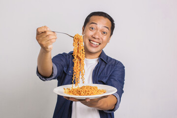 
Asian man eating instant noodle and feel surprise with how delicious it is
