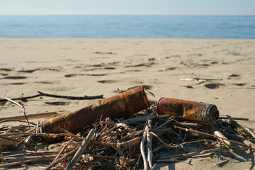 Old rusted spray cans discarded on sea coast ecosystem,nature pollution contamination