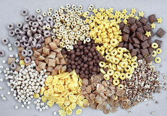 Various breakfast cereals on light grey background, assorted corn flakes in bowls, quick food for kid breakfast