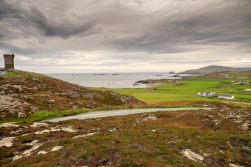 Small road to Malin head viewpoint and stunning scenery. Dark dramatic cloudy sky. Amazing Irish landscape. County Donegal, Ireland.