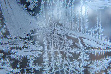 frosty patterns on the window glass closeup. natural textures and backgrounds. ice patterns on...