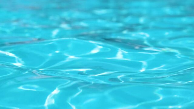 Closeup surface of blue clear water with small ripple waves in swimming pool