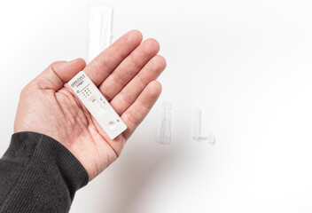 Caucasian man's hand showing a rapid antigen test on a white background. Covid-19 Concept