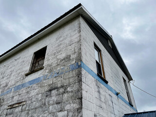 Old creepy scary abandoned building corner view white faded wall