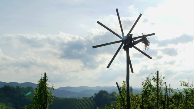 Styrian wind wheel (Klapotetz) with clouds moving by in the background - timelapse.