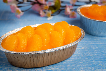 Orange Sponge Cake topping with Sliced Orange in a tinfoil, made from organic fresh orange juice, on wooden table