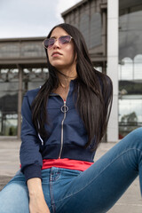 young latin woman with long, straight black hair, wears a casual jacket and heart-shaped glasses, lifestyle, beauty and fashion in the city