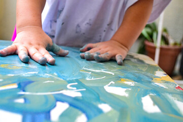 manitos de una niña pintando