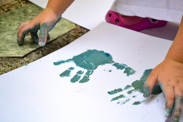 Fototapeta na wymiar manitos de una niña pintando
