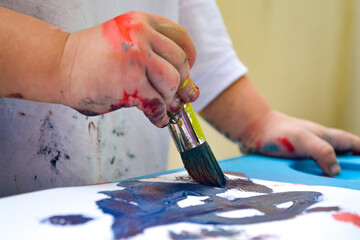 manitos de una niña pintando